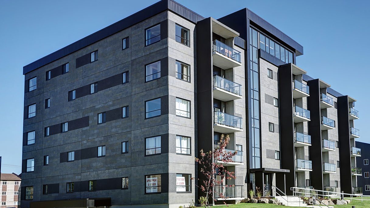 Le Luxenbourg I, immeuble de pierre grise et de métal noir sur pelouse